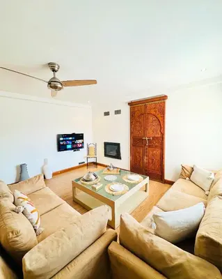 a living room with a couch and a table at Magnifique 2 chambres Terrasse et Wifi à Marrakech in Marrakech
