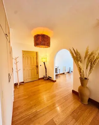 a living room with a vase on a hard wood floor at Magnifique 2 chambres Terrasse et Wifi à Marrakech in Marrakech