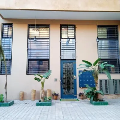 a house with a blue door and some plants at Cozy Apartment in Hay Charaf district, Marrakech in Marrakech