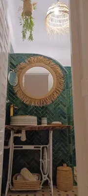a bathroom with a mirror on a green tiled wall at Riad Kechin Beldi in Marrakech
