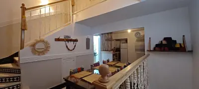 a hallway with a staircase with a table and a kitchen at Riad Kechin Beldi in Marrakech