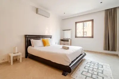 a bedroom with a large bed with yellow pillows at Cozy Studio in city center Guéliz in Marrakech