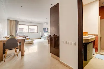 a kitchen and living room with a table and a dining room at Cozy Studio in city center Guéliz in Marrakech