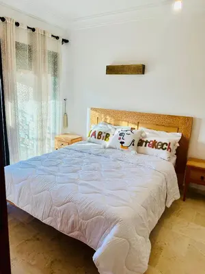 a bedroom with a large bed with white sheets and pillows at cozy appartement in Marrakech