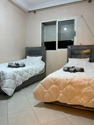 two beds sitting next to each other in a room at Cozy Apartment Near Airport in Marrakech