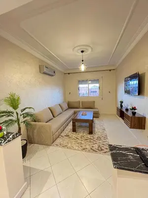 a living room with a couch and a table at Cozy Apartment Near Airport in Marrakech
