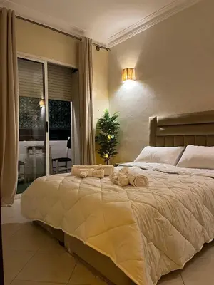 a bedroom with a large bed with towels on it at Cozy Apartment Near Airport in Marrakech