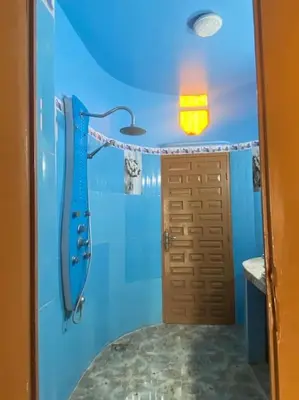 a blue bathroom with a shower and a door at La porte d Or in Marrakech