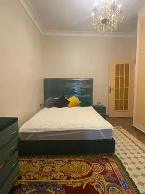 a bedroom with a bed and a chandelier at La porte d Or in Marrakech