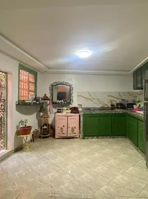 a large kitchen with green cabinets and a mirror at La porte d Or in Marrakech