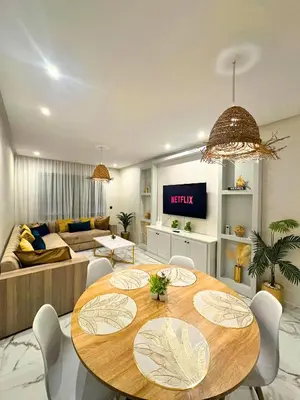 a living room with a table and a couch at La Palmeraie Luxueux avec Piscine et Parking in Marrakech