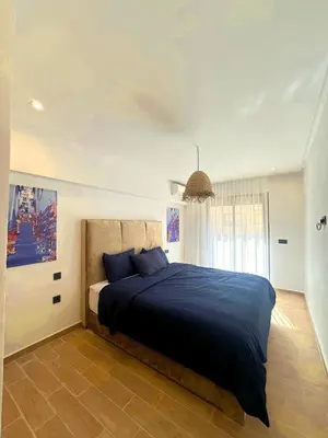 a bedroom with a large bed with a blue blanket at La Palmeraie Luxueux avec Piscine et Parking in Marrakech