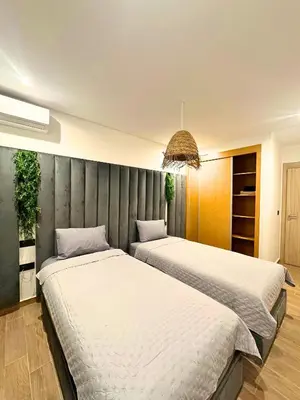 two beds sitting next to each other in a room at La Palmeraie Luxueux avec Piscine et Parking in Marrakech