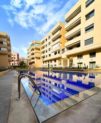 a swimming pool in front of a building at La Palmeraie Luxueux avec Piscine et Parking in Marrakech