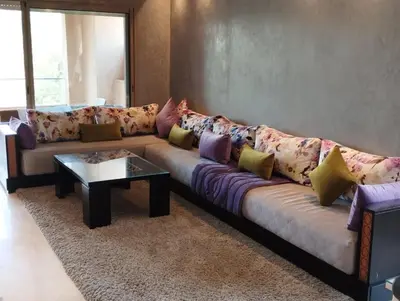 a living room with a couch with colorful pillows at Prestigia appartement in Marrakech