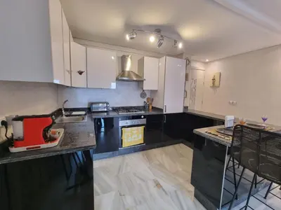 a kitchen with white cabinets and a red appliance on the counter at Shine house in Marrakech