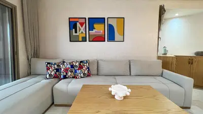a living room with a couch and a table at Appartement Marrakech prestigia by Sofia 2 chambres piscine in Marrakech