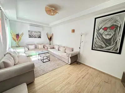 a living room with a couch with red glasses on the wall at Appart cozy hyper centre calme in Marrakech