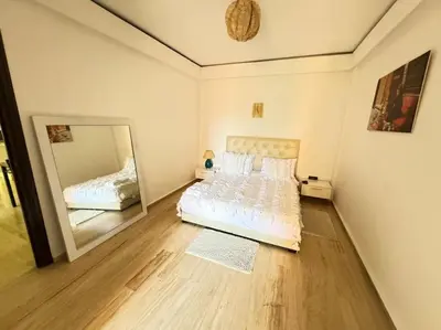a bedroom with a bed and a large mirror at Appart cozy hyper centre calme in Marrakech