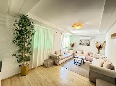 a living room with a couch and a plant at Appart cozy hyper centre calme in Marrakech