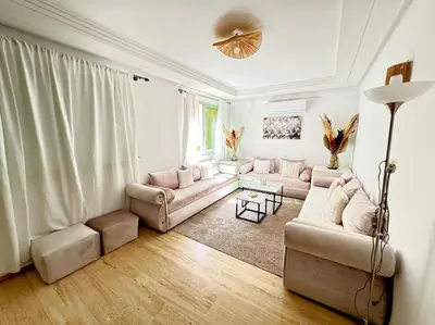 a living room with two couches and a table at Appart cozy hyper centre calme in Marrakech