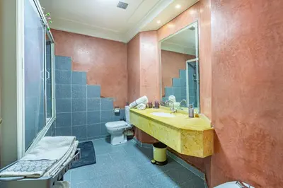 a bathroom with a sink and a toilet and a mirror at Appartement Duplex confort qualité très bien situé in Marrakech