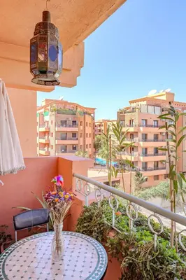 a vase of flowers sitting on a table on a balcony at Appartement Duplex confort qualité très bien situé in Marrakech