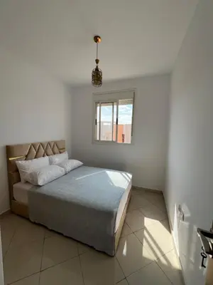 a bedroom with a large bed with a window at Location Familiale à Marrakech in Marrakech