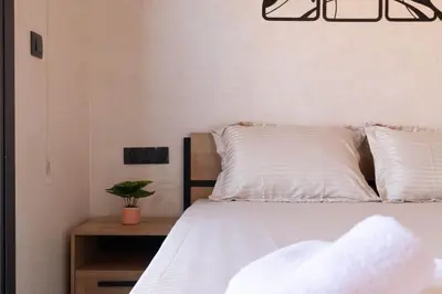 a bedroom with a bed with white sheets and a table at Studio moderne à deux pas du coeur de la ville in Marrakech