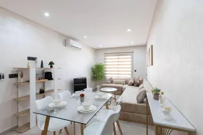 a white living room with a table and white chairs at Studio moderne à deux pas du coeur de la ville in Marrakech