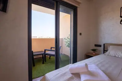 a bedroom with a bed and a view of a balcony at Studio moderne à deux pas du coeur de la ville in Marrakech