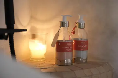 two bottles sitting next to a candle and a glass at Riad Solange in Marrakech