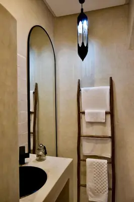 a bathroom with a sink and a mirror and towels at Riad Solange in Marrakech