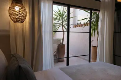 a bedroom with a bed and a large glass door at Riad Solange in Marrakech