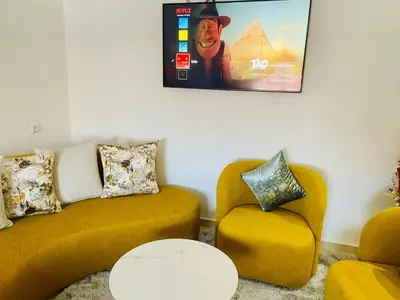 a living room with a couch and a chair at Nomad's Cosy Apartment Gueliz Center in Marrakech