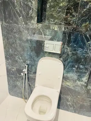 a white toilet in a bathroom with a marble wall at Nomad's Cosy Apartment Gueliz Center in Marrakech