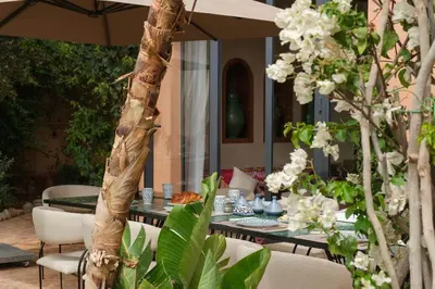 a table with chairs and an umbrella on a patio at Villa à Marrakech in Marrakech