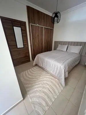a bedroom with a bed and a wooden door at Appartement Marrakech aéroport Menara airport Gueliz in Marrakech
