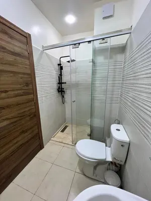 a bathroom with a toilet and a glass shower at Appartement Marrakech aéroport Menara airport Gueliz in Marrakech
