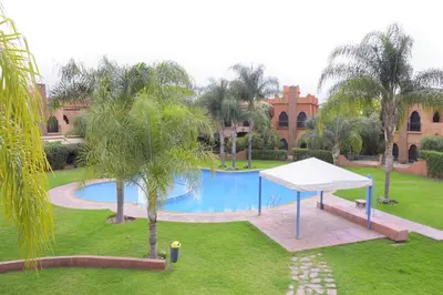 a ping pong table in front of a pool at Capstay Riad Villa in secure residence in Marrakech
