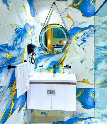 a bathroom with a mirror on a blue and gold wall at 17 - Top Location, NEUF, piscine & Comfort in Marrakech
