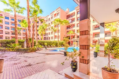 an apartment courtyard with palm trees and a swimming pool at 17 - Top Location, NEUF, piscine & Comfort in Marrakech