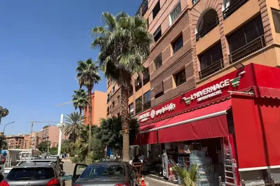 a street with cars parked in front of a building at Apartment in Centre of Marrakech in Marrakech