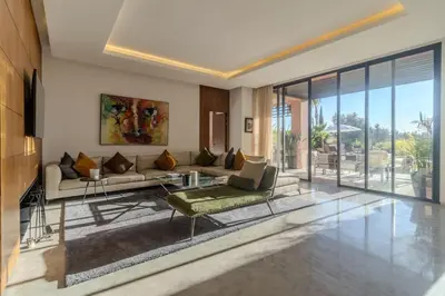 a living room with a couch and a table at HM50 l Villa en front de golf piscine & jacuzzi in Marrakech