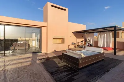 a house with a hot tub on a patio at HM50 l Villa en front de golf piscine & jacuzzi in Marrakech