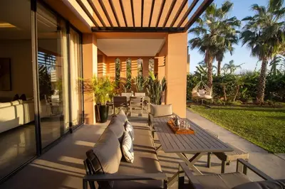 a patio with a table and chairs on a house at HM50 l Villa en front de golf piscine & jacuzzi in Marrakech
