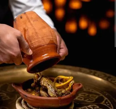 a person is holding a hand mixer over a bowl of food at Duplex tres beau avec wifi in Marrakech