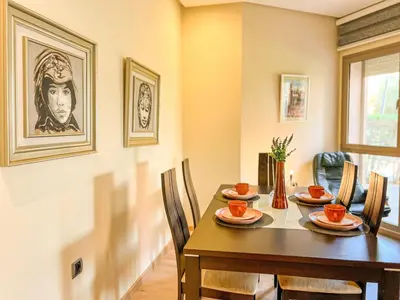 a dining room with a wooden table and chairs at Serene Stay Cozy Flat in Marrakech in Marrakech