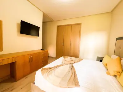a bedroom with a bed with a tv on the wall at Serene Stay Cozy Flat in Marrakech in Marrakech