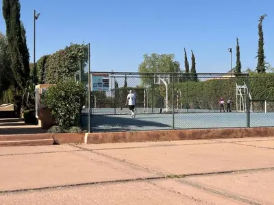 a person is playing tennis on a tennis court at appart jardin de l atlas Marrakech Waky Beach Golf Montagne de l Atlas in Marrakech